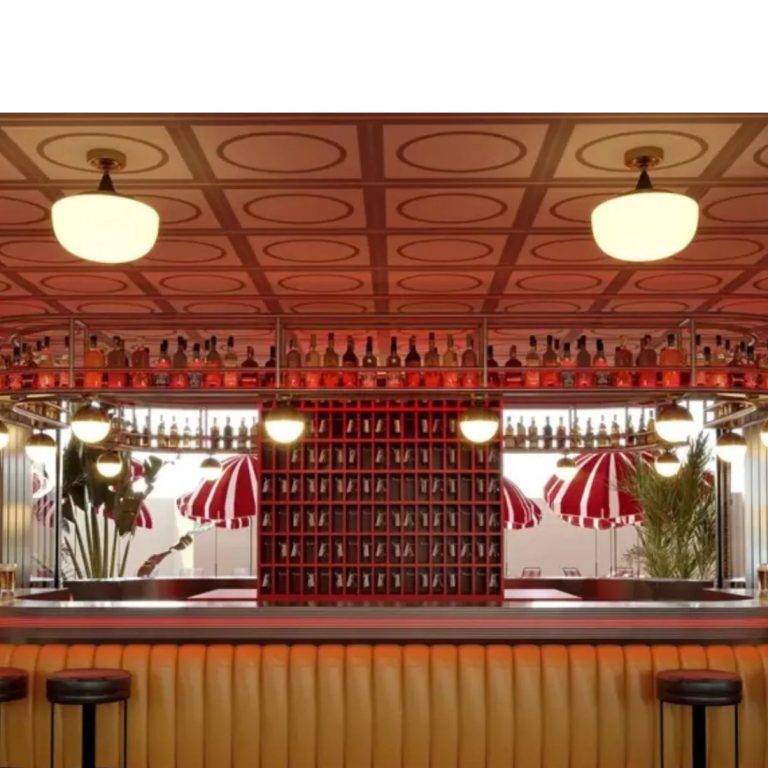 Bar de estilo retro con barra iluminada, taburetes y decoración en tonos rojos y cálidos.