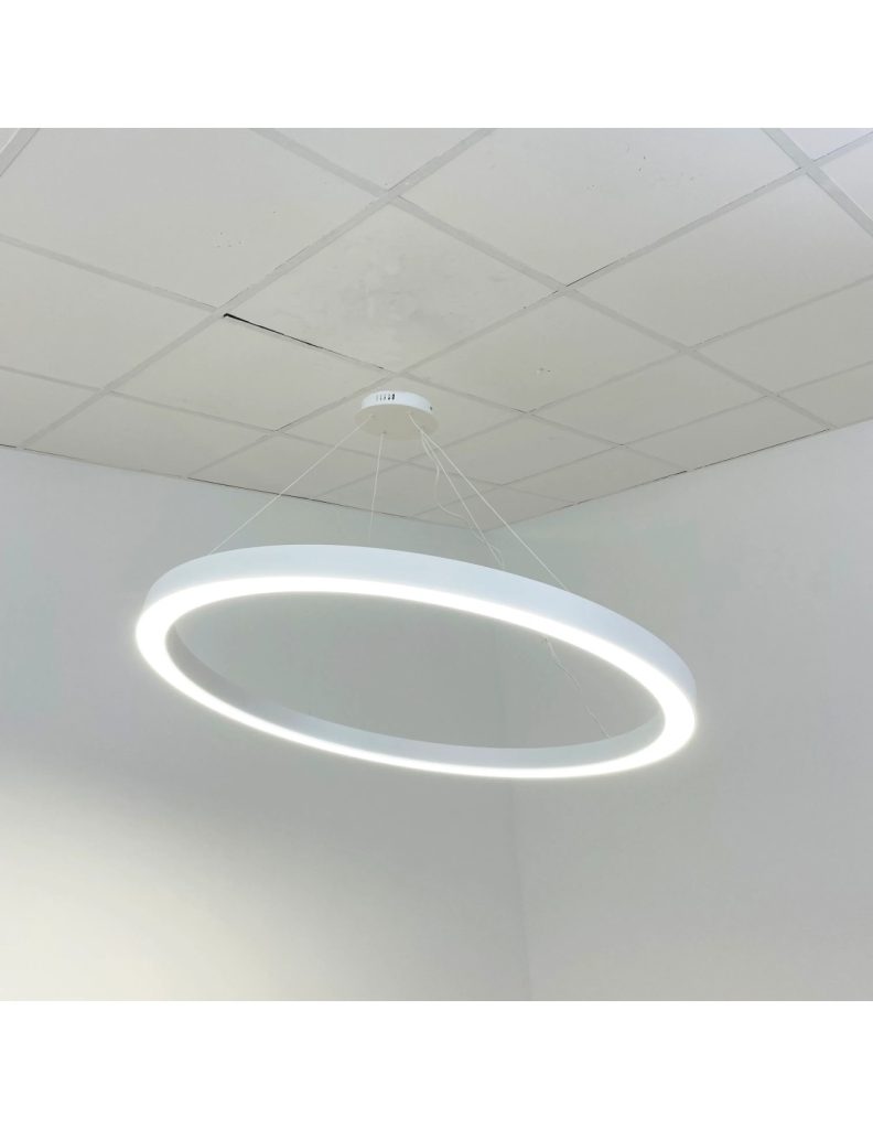 Lámpara colgante LED en forma de anillo instalada en techo con paneles, iluminando con luz blanca uniforme