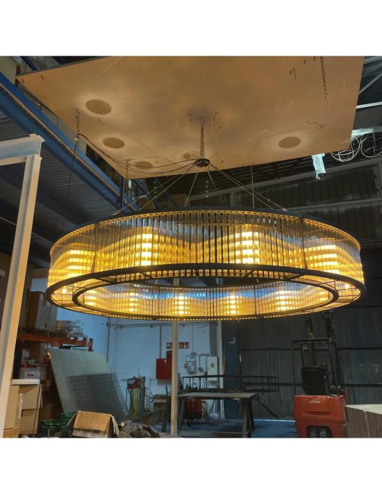 Lámpara colgante circular grande con diseño industrial y luz cálida tipo vintage en proceso de instalación