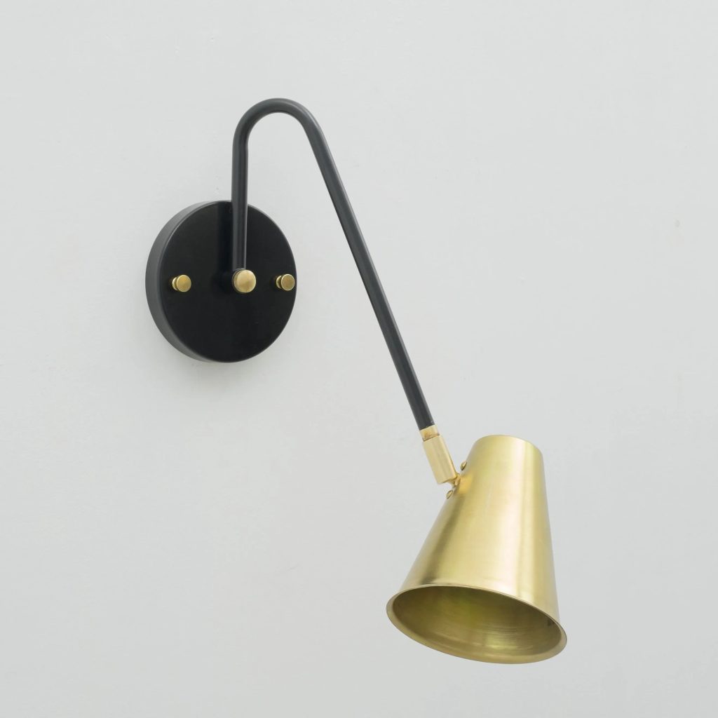 Aplique de pared orientable en negro y latón con pantalla metálica cónica de estilo vintage.