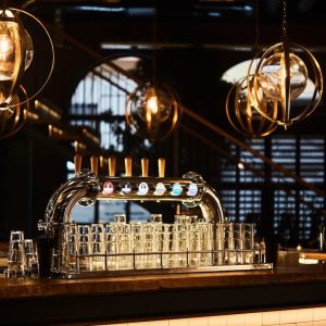 Lámparas colgantes decorativas de estilo industrial con esferas metálicas doradas en un bar contemporáneo.