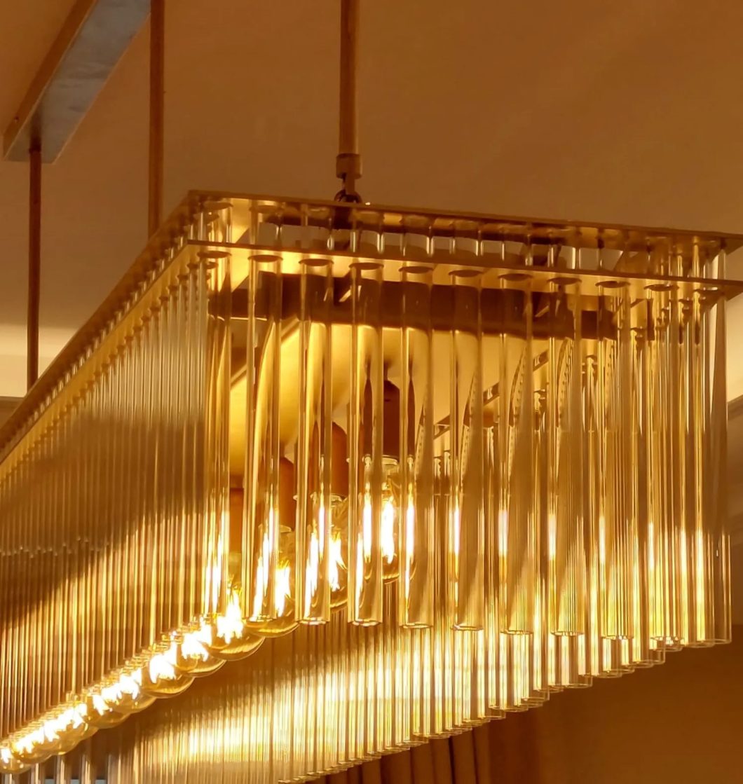 Lámpara colgante rectangular con tubos de cristal y luz cálida en diseño elegante y sofisticado.