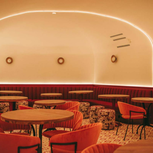Espacio de restauración con iluminación cálida indirecta y apliques circulares de estilo contemporáneo.