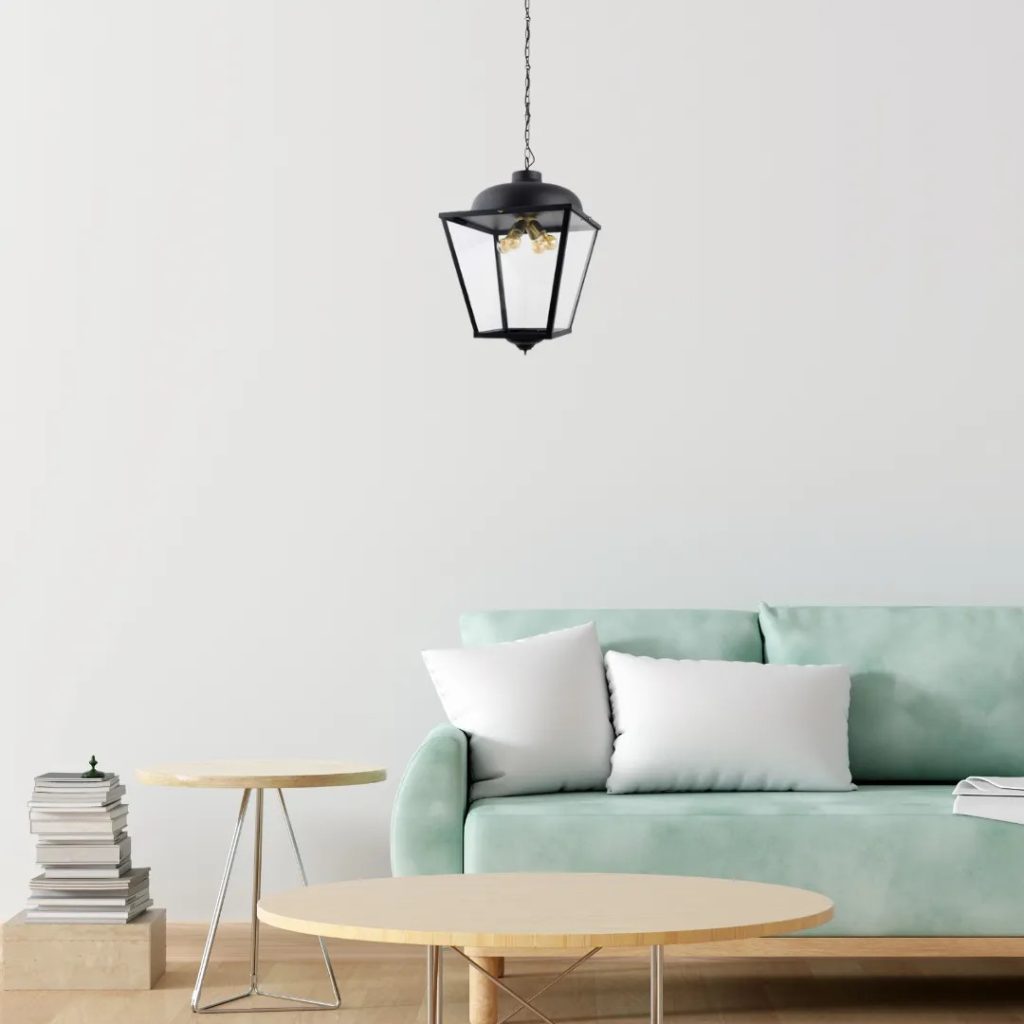 Lámpara colgante estilo farol en acabado negro suspendida sobre un salón minimalista contemporáneo.