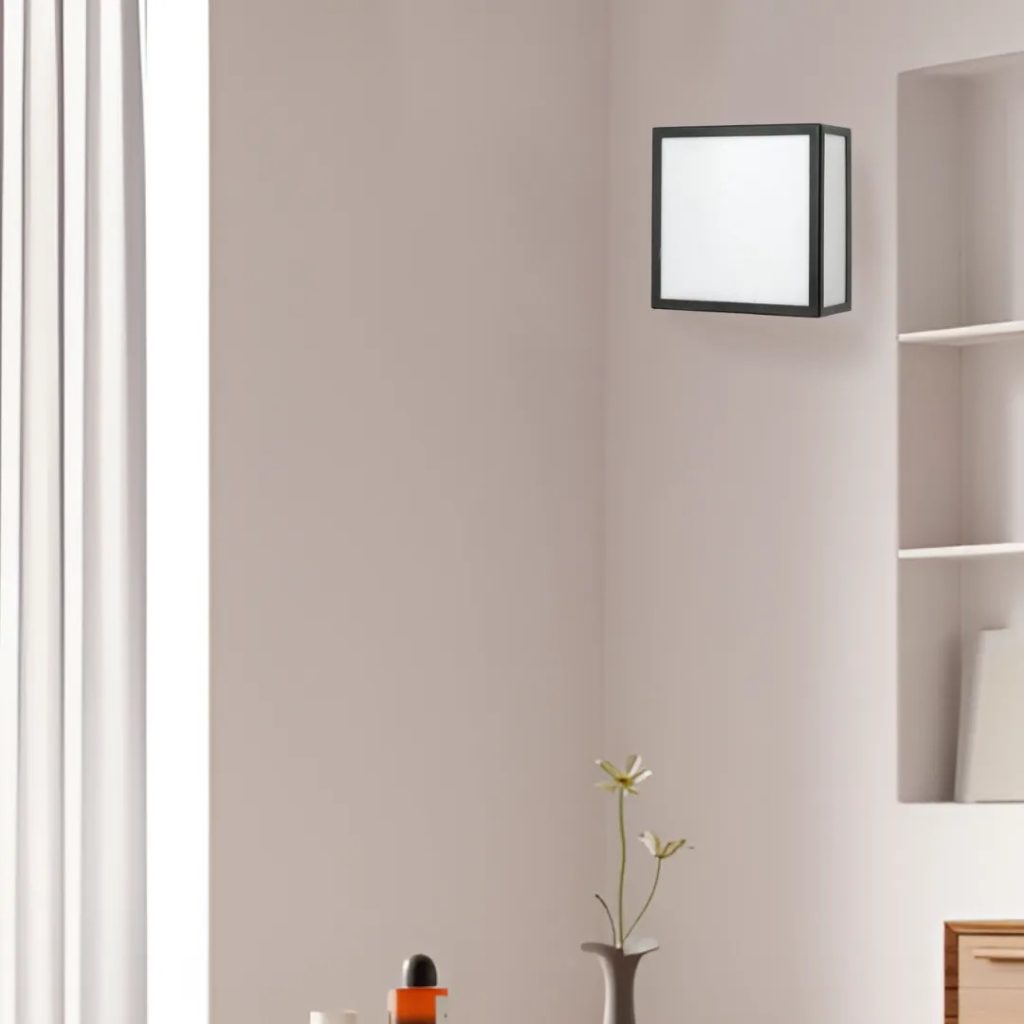 Aplique de pared cuadrado con estructura negra y pantalla blanca en un interior minimalista y luminoso.
