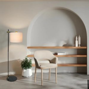 Lámpara de pie minimalista junto a un sillón en un salón de estilo contemporáneo y cálido.