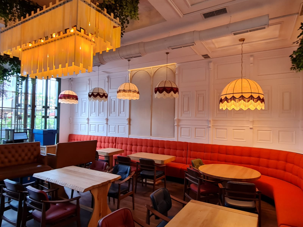 Lámparas colgantes decorativas iluminando el interior de un restaurante de estilo elegante y acogedor.