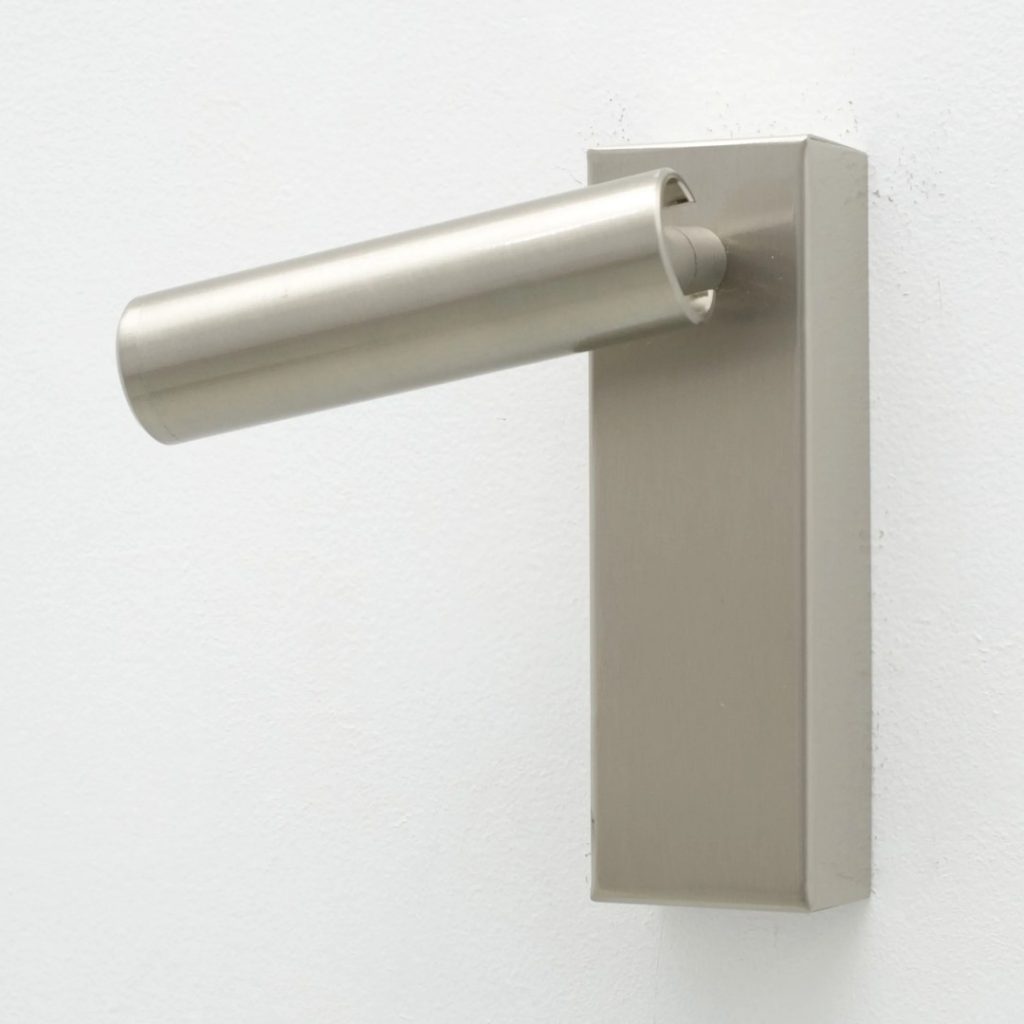 Aplique de pared orientable en acabado metálico satinado con diseño cilíndrico.