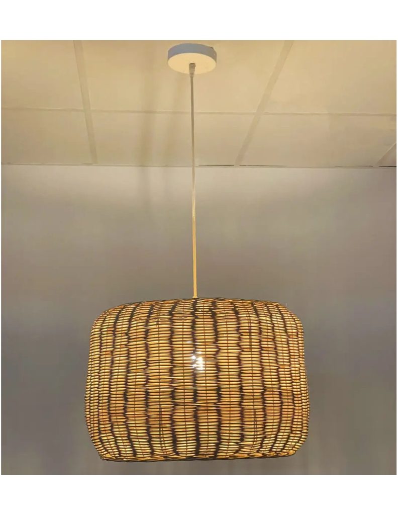 Lámpara colgante de mimbre con pantalla cilíndrica que proyecta una luz cálida y decorativa.
