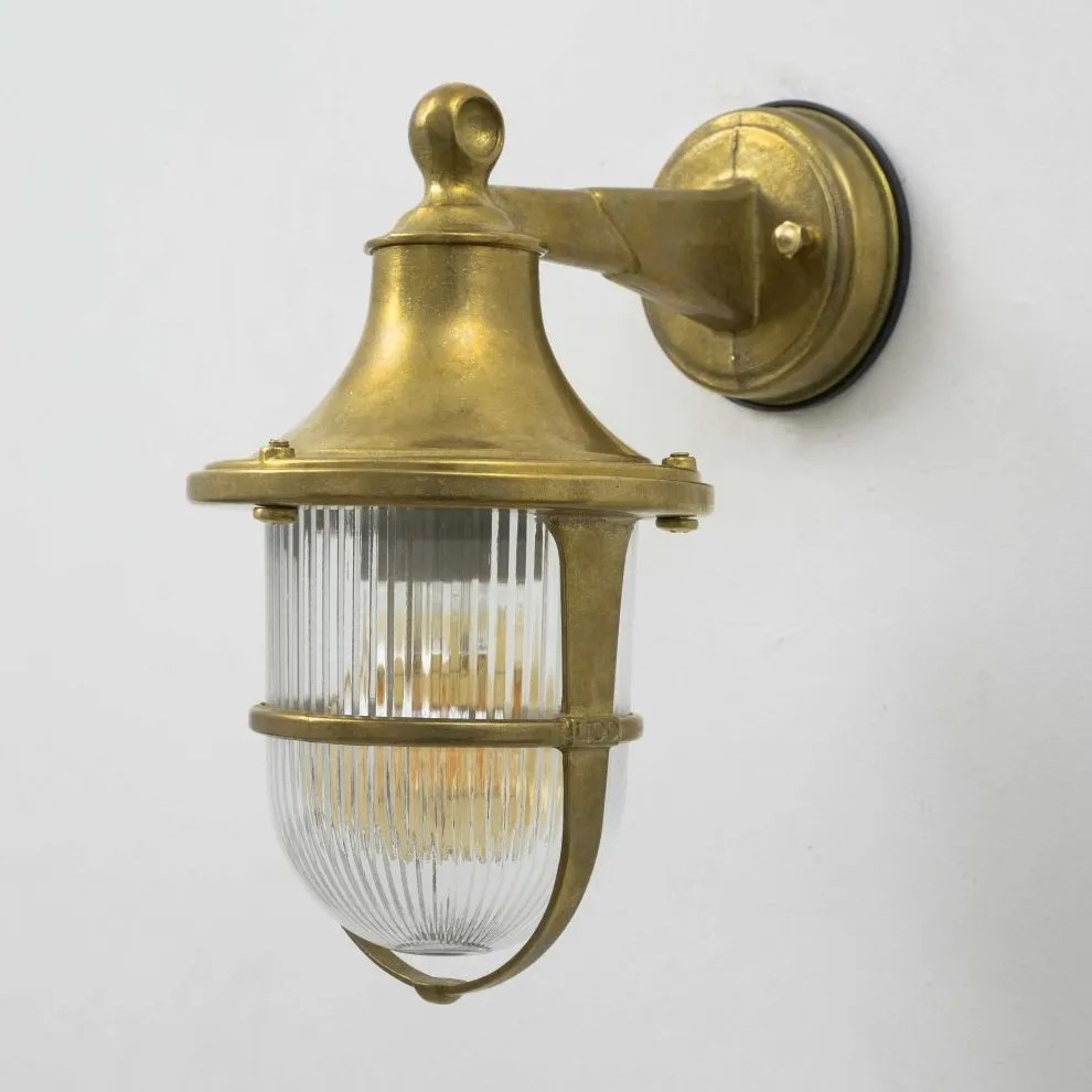 Aplique de pared vintage en latón con tulipa de cristal estriado y diseño náutico decorativo.