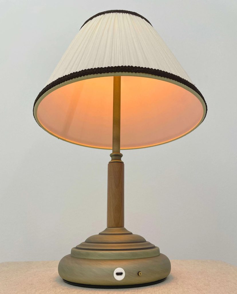 Lámpara de sobremesa vintage con base de madera, pantalla plisada beige e iluminación cálida.