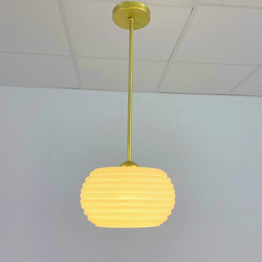 Lámpara colgante vintage con tulipa ovalada de cristal opal estriado y estructura en latón.