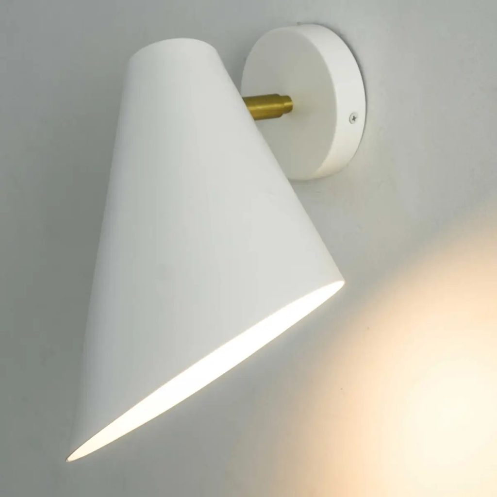 Aplique de pared blanco con pantalla cónica orientable, detalle dorado e iluminación cálida.