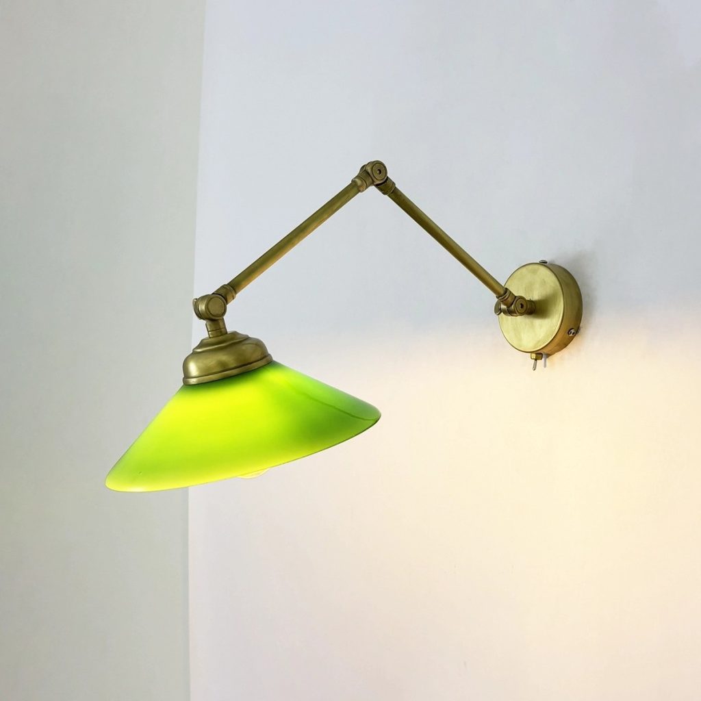 Aplique de pared vintage articulado en latón envejecido con pantalla verde, ideal para iluminación decorativa de lectura, dormitorio o salón.