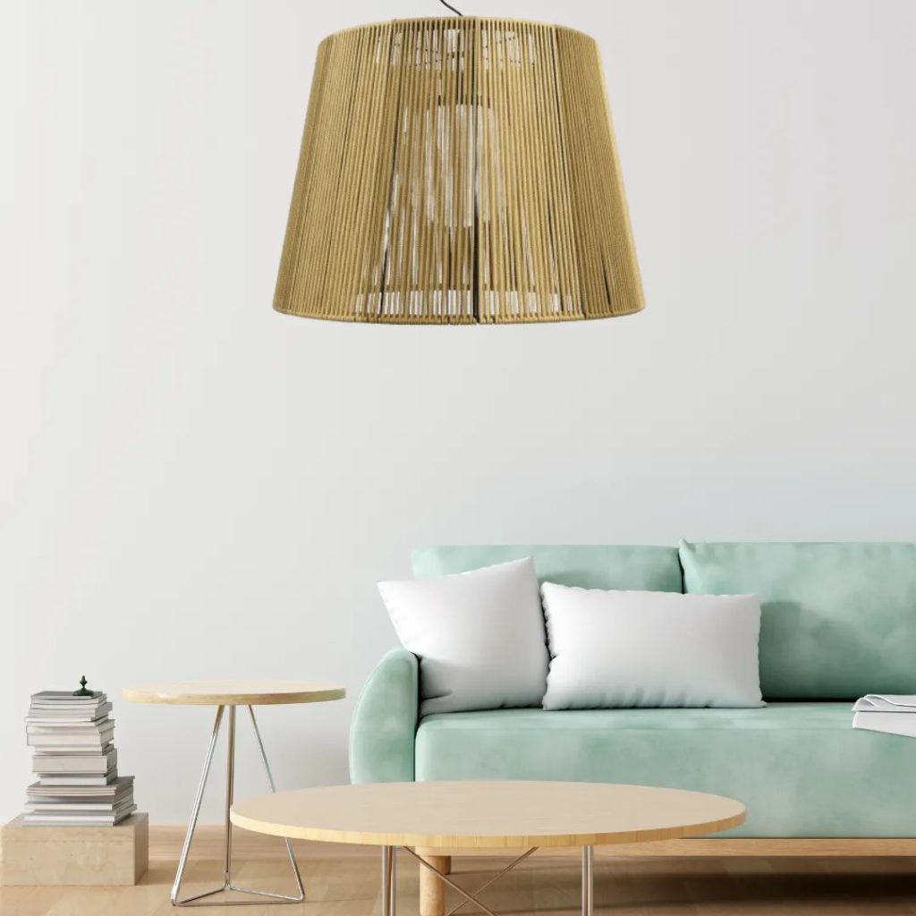 Lámpara colgante de fibra natural con pantalla cilíndrica sobre un salón minimalista con sofá verde agua.
