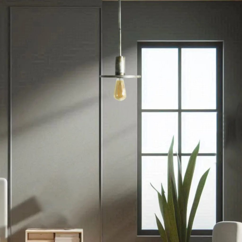 Lámpara colgante minimalista con bombilla vista en un interior moderno con pared gris, ventana negra y planta decorativa