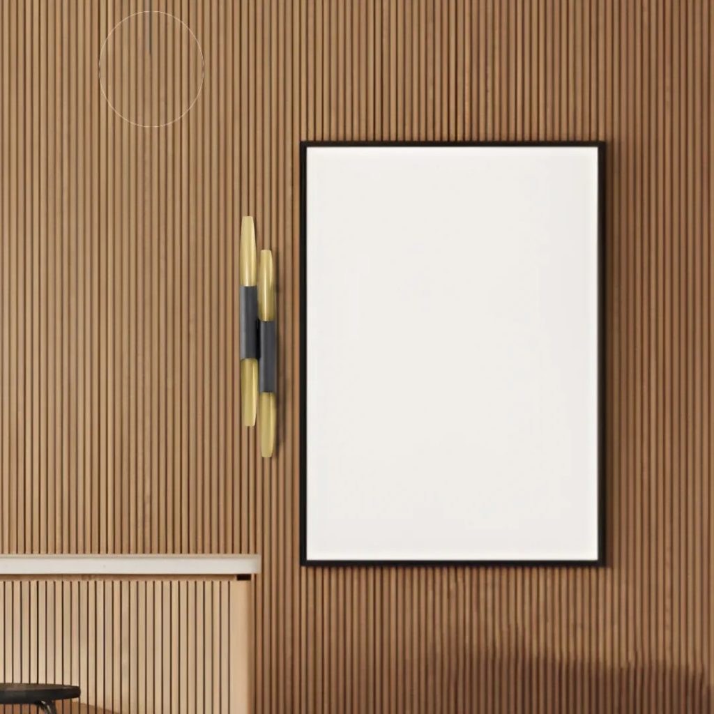 Aplique de pared vertical en acabado negro y latón instalado sobre pared de listones de madera junto a espejo decorativo.