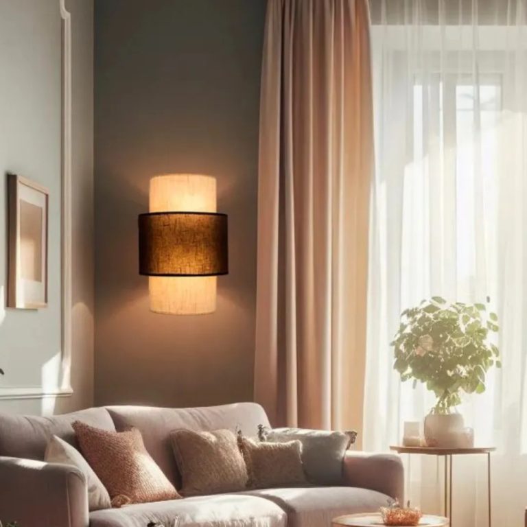 Aplique de pared vintage con dos pantallas cilíndricas de tela superpuestas, iluminando un salón en tonos neutros.