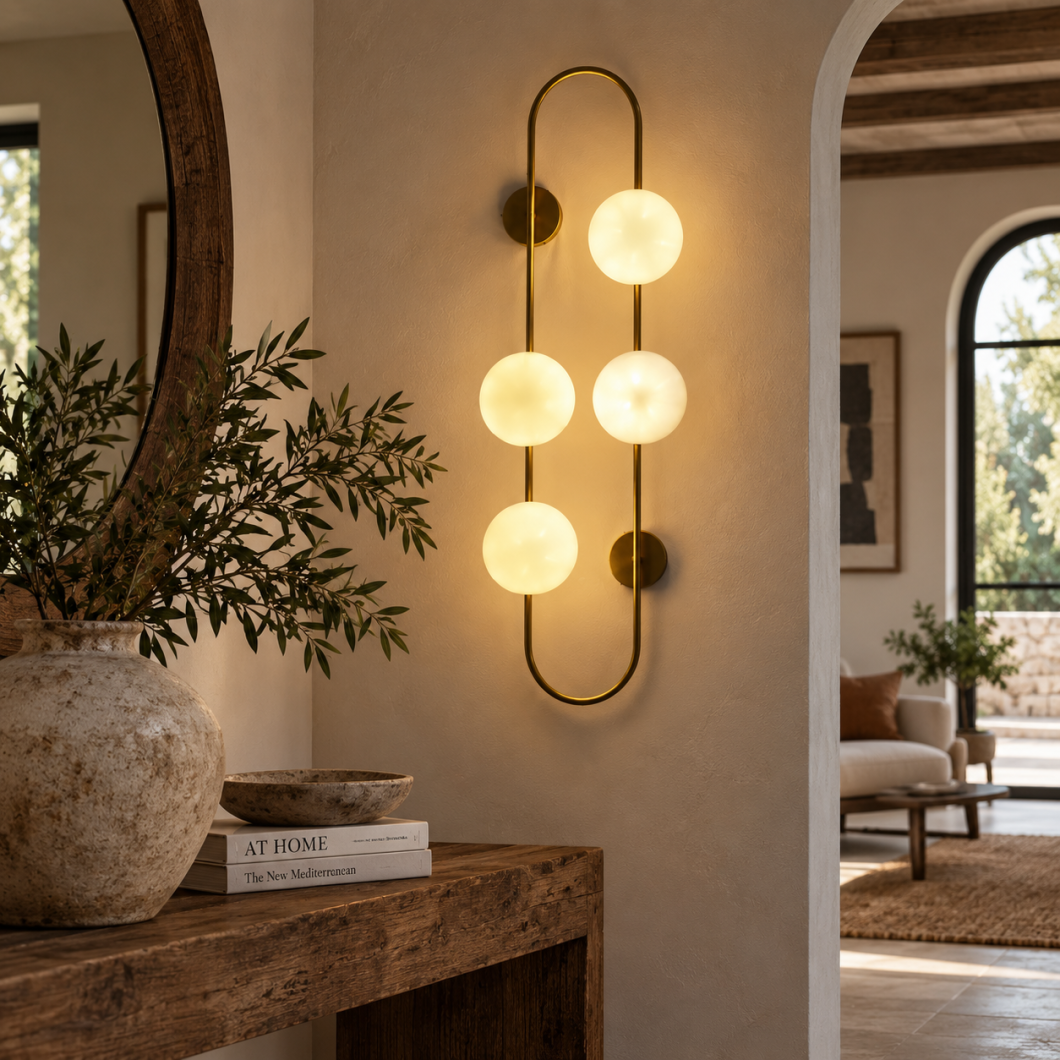 Aplique Palma de latón envejecido con cuatro bolas de cristal opal iluminando una pared.