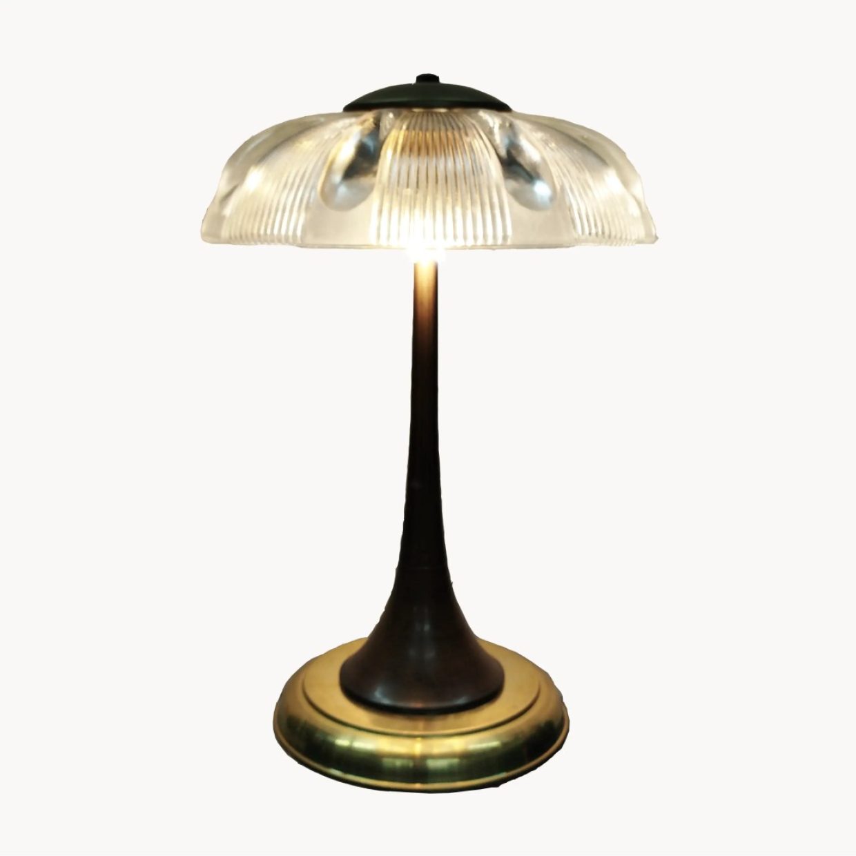 Lámpara de mesa vintage con base metálica y pantalla de cristal estriado, diseño elegante y luz suave.