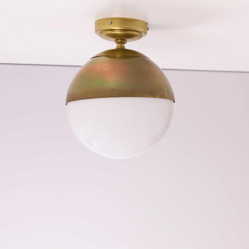 Plafón de techo vintage con estructura dorada y difusor esférico de cristal opal blanco, de diseño elegante y atemporal.